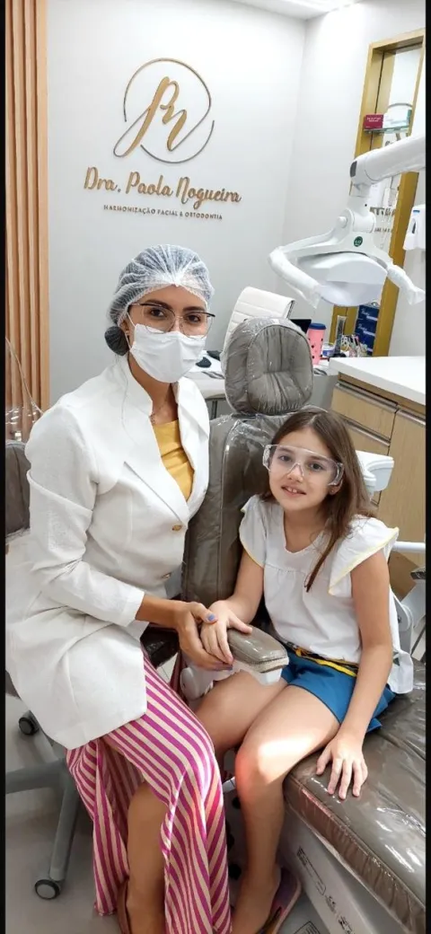 Dra. Paola atendendo uma jovem paciente no consultório