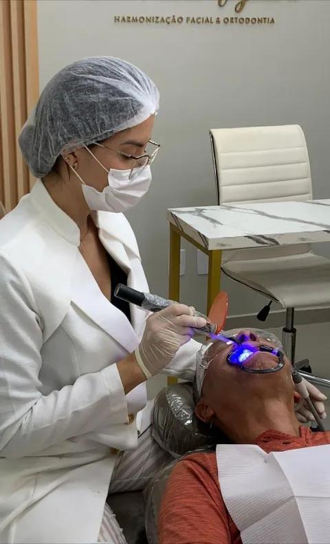 Dra. Paola realizando procedimento com fotoativação